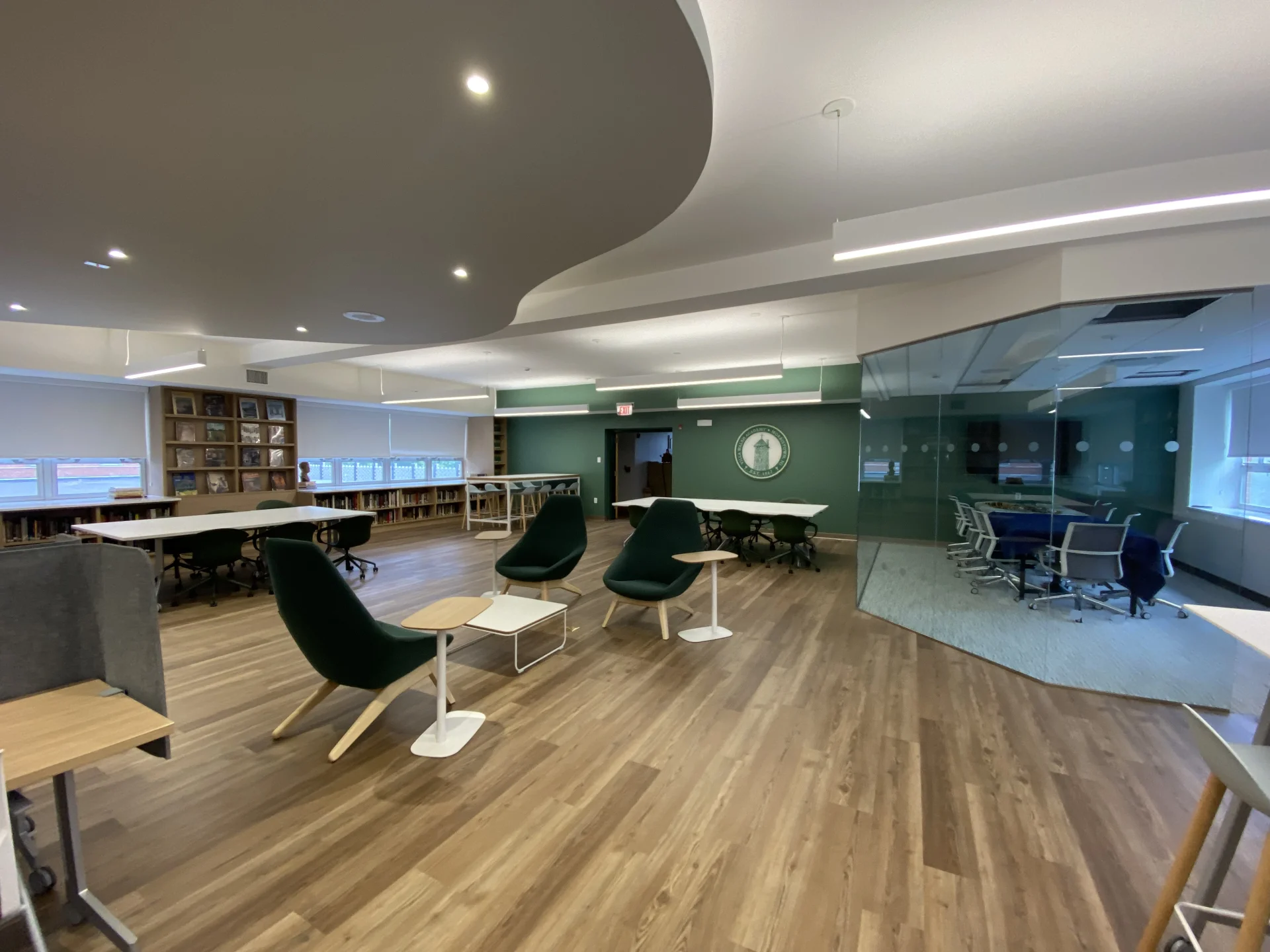 student work desks and green logo wall