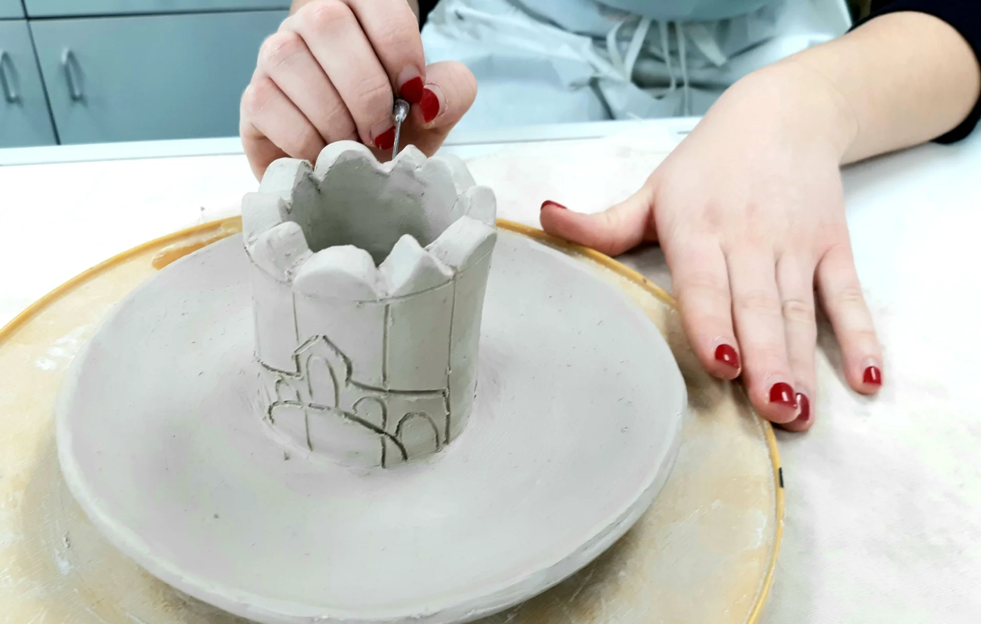 student engraving pottery