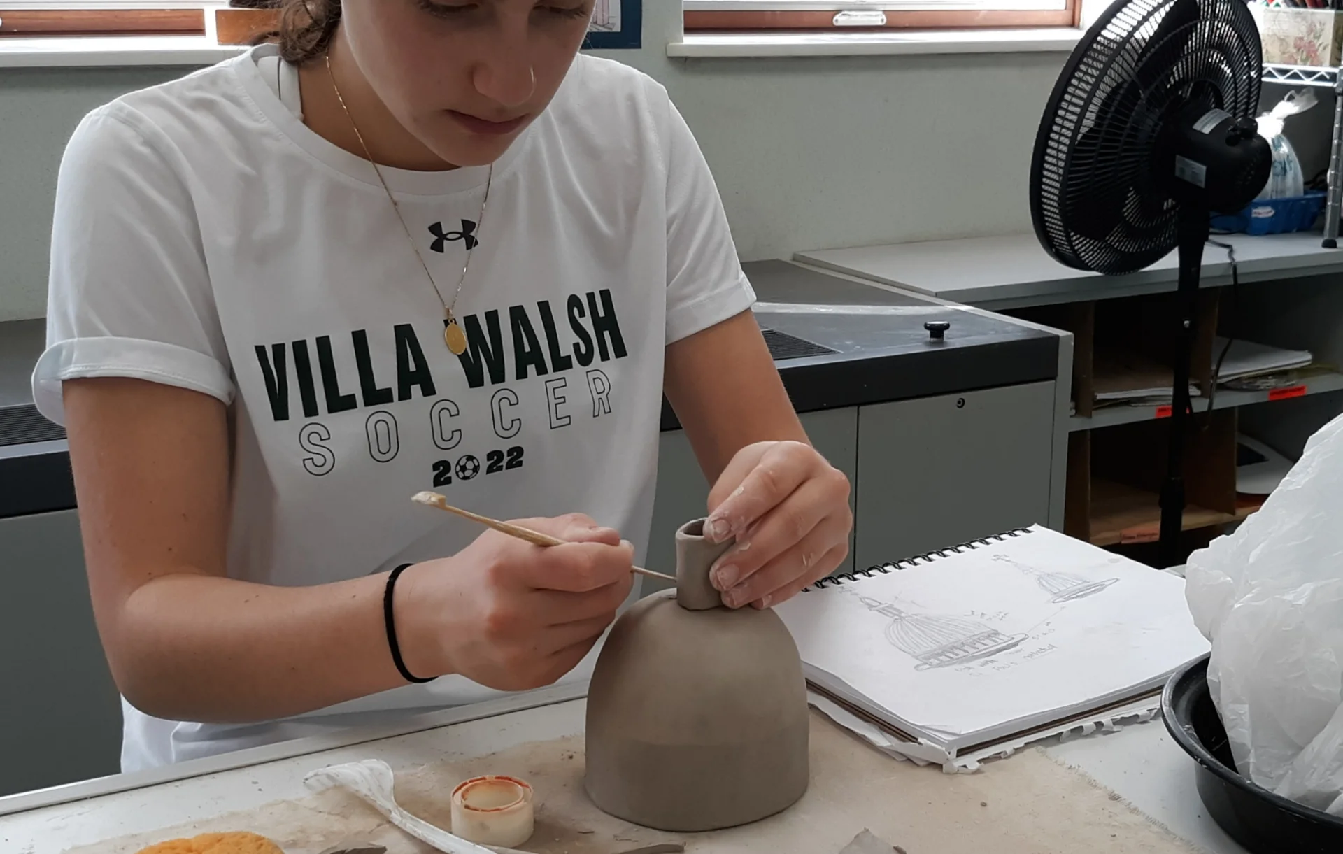 student creating pottery