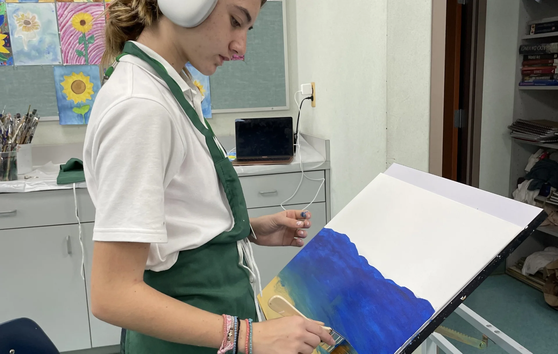 student painting and listening to music