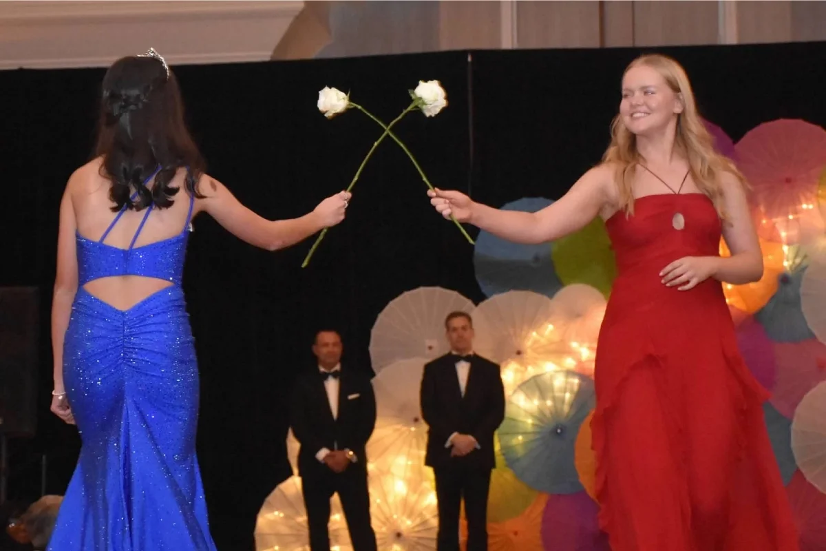 two students crossing rose stems on the runway