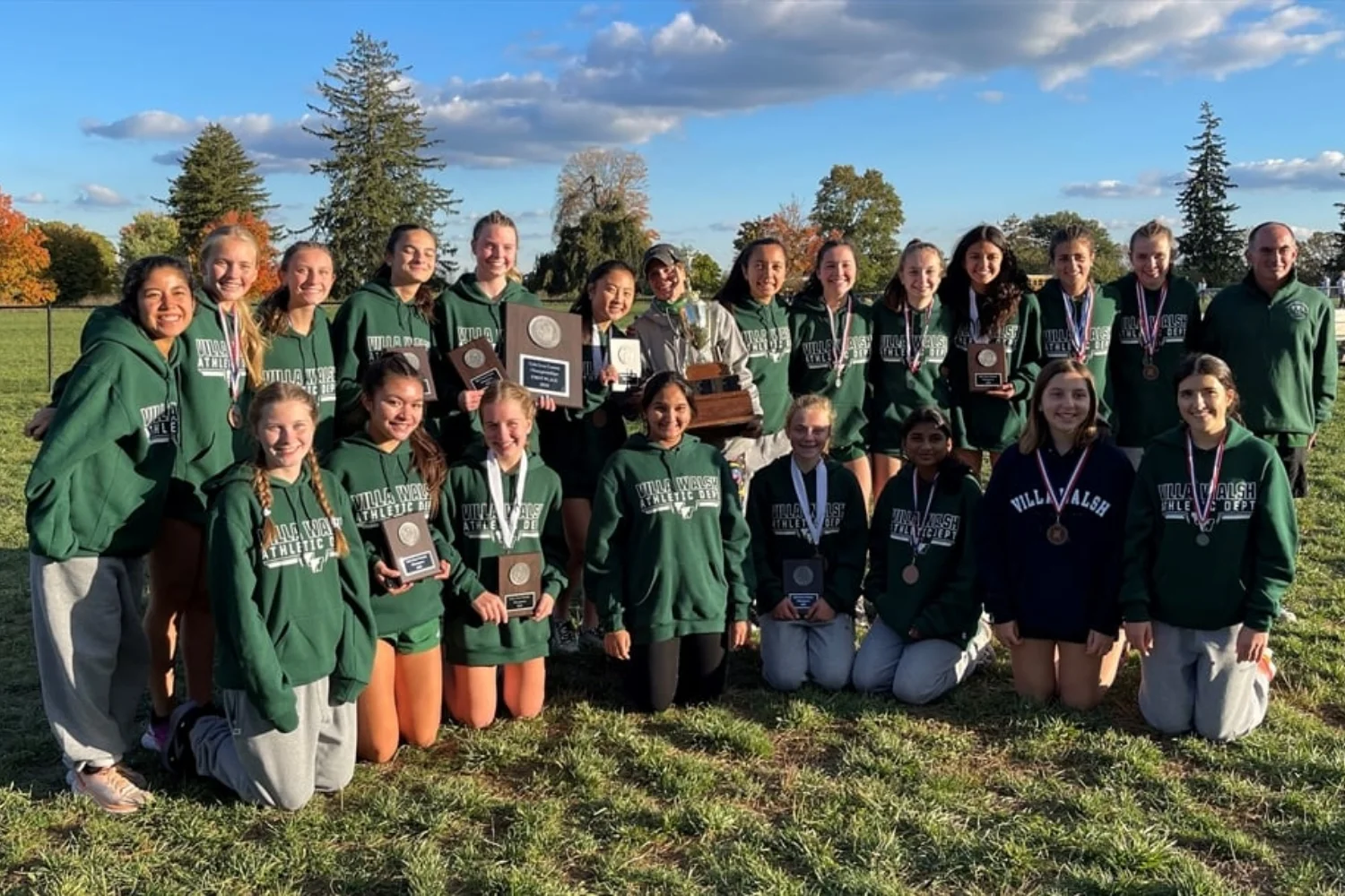 VWA cross country team wearing medals and holding award plaques