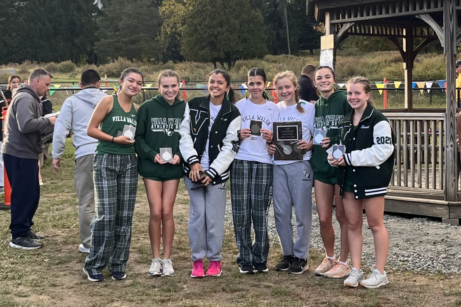 Cross Country team holding award plaques