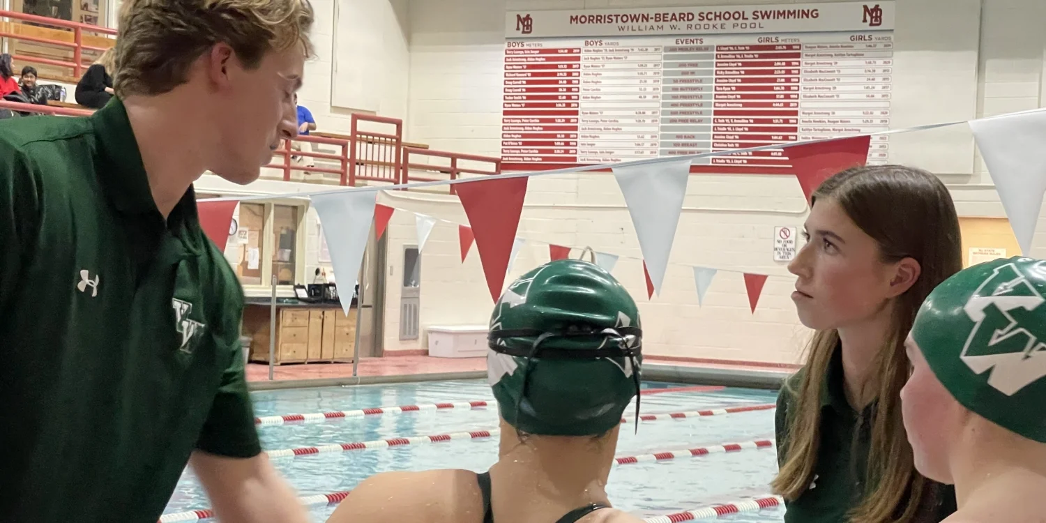 VWA swim team members talking to coach