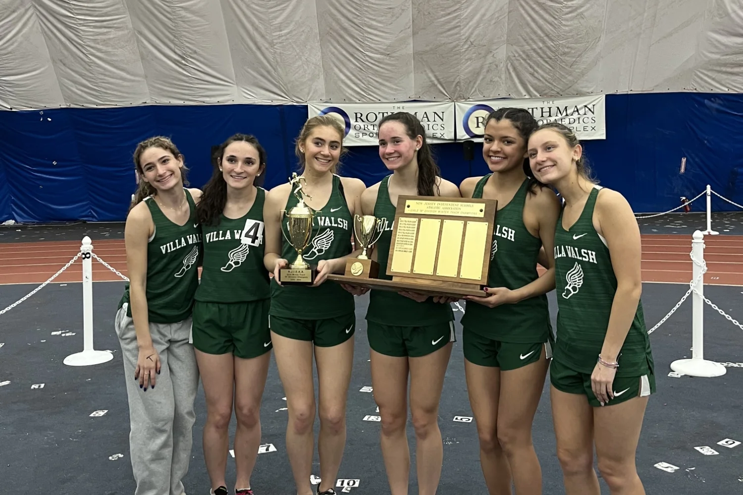 winter track team holding award plaque