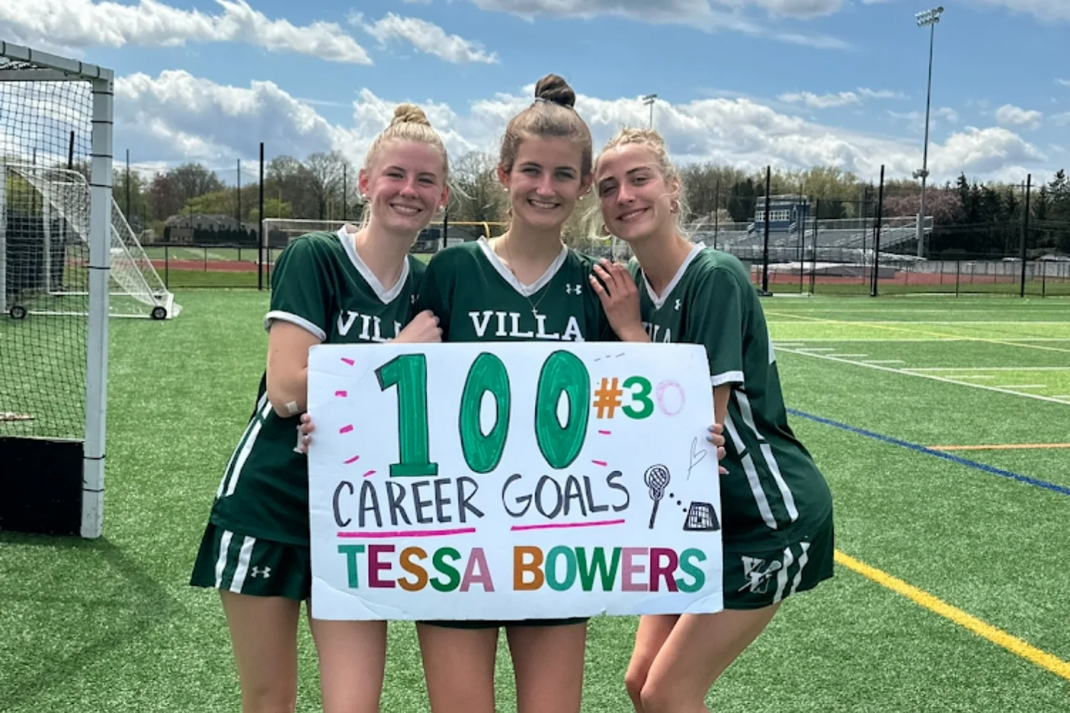 lacrosse students with sign for Tessa Bower's 100th career goal