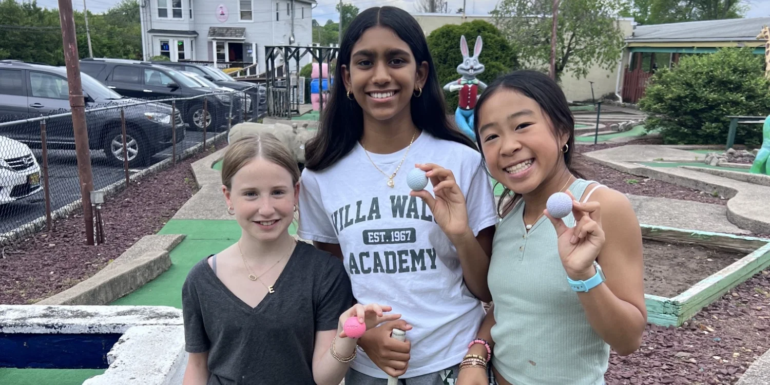 3 spring clinic students posing with golf balls