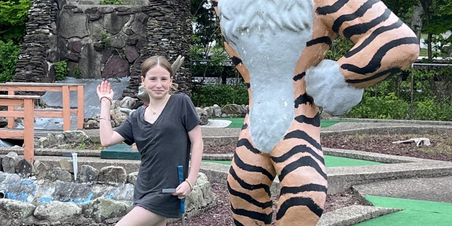 spring clinic student posing with tiger mini golf statue