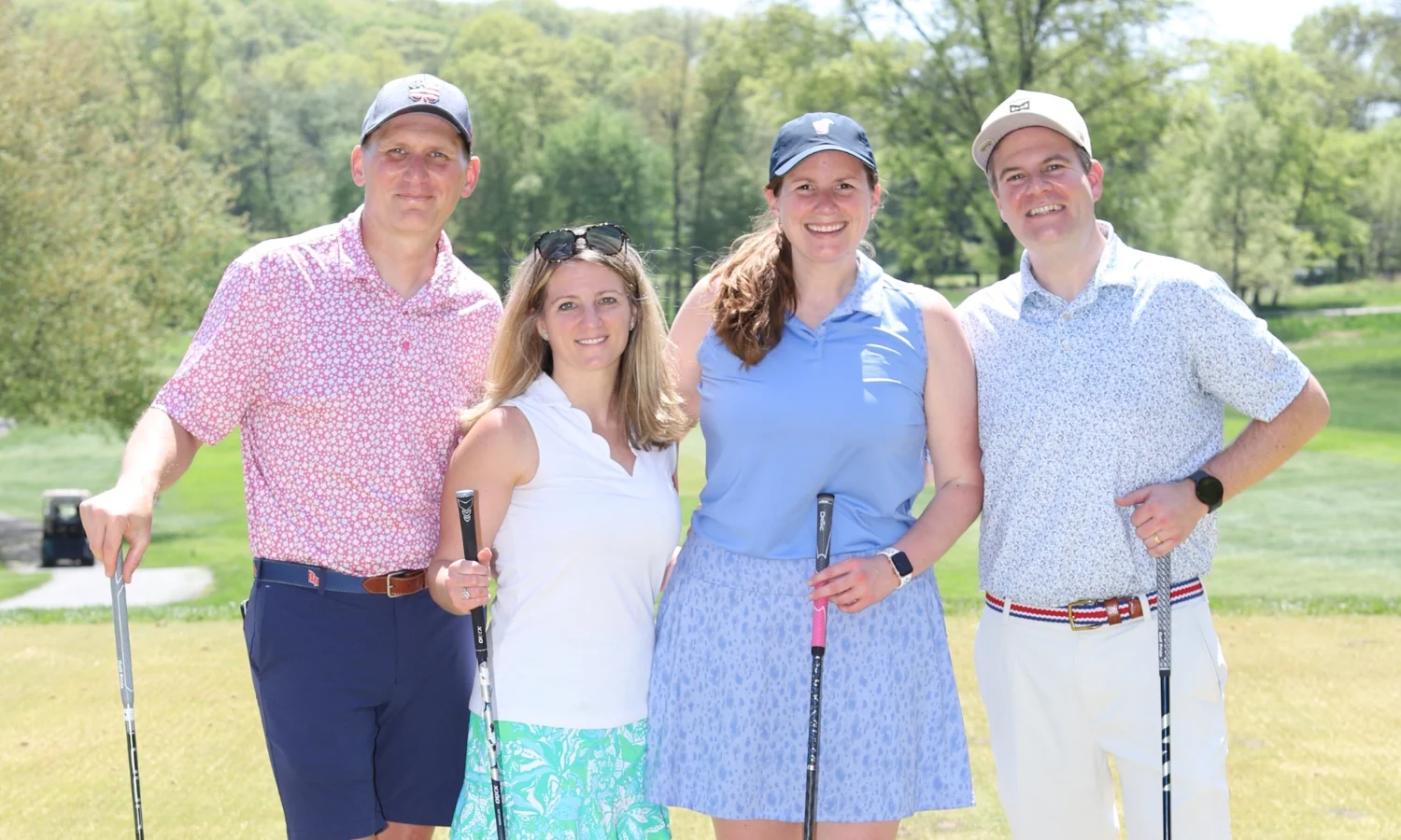 4 adults in golf dress on the green