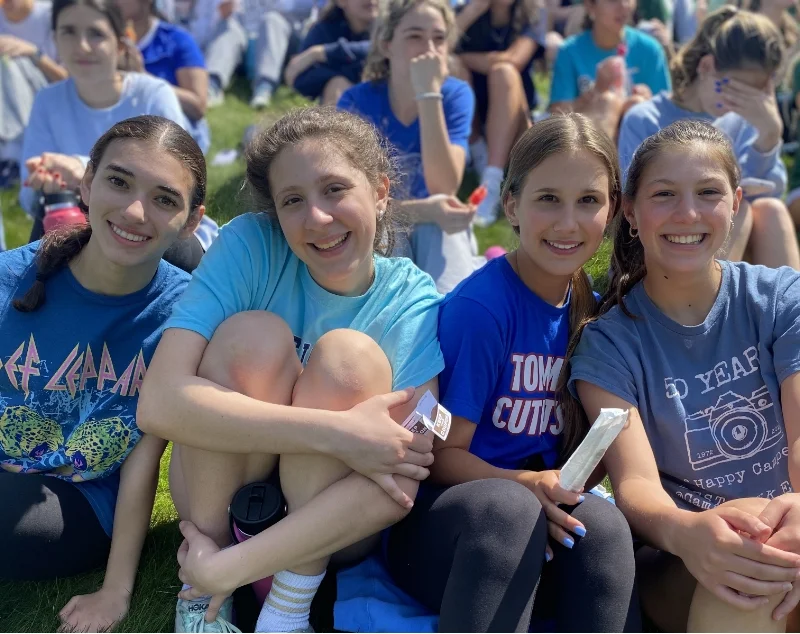 students sitting together on a grassy hill