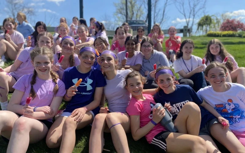 group of happy students sitting in the field